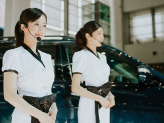 Acheteur examina attentivement la carrosserie et l'intérieur d'une berline d'occasion en concession automobile